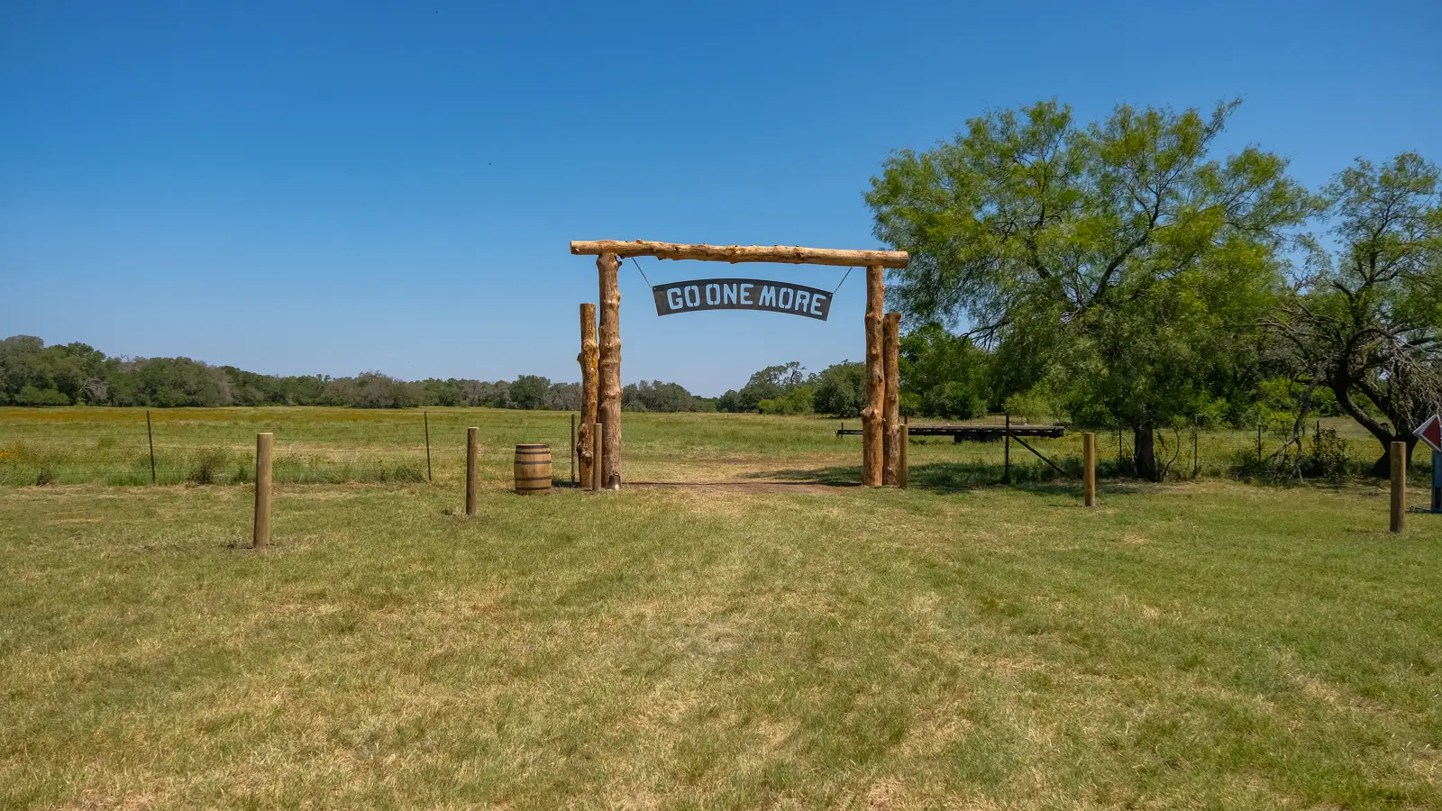 Timber finish-line arch overlooking the open landscape at Bare Ranch