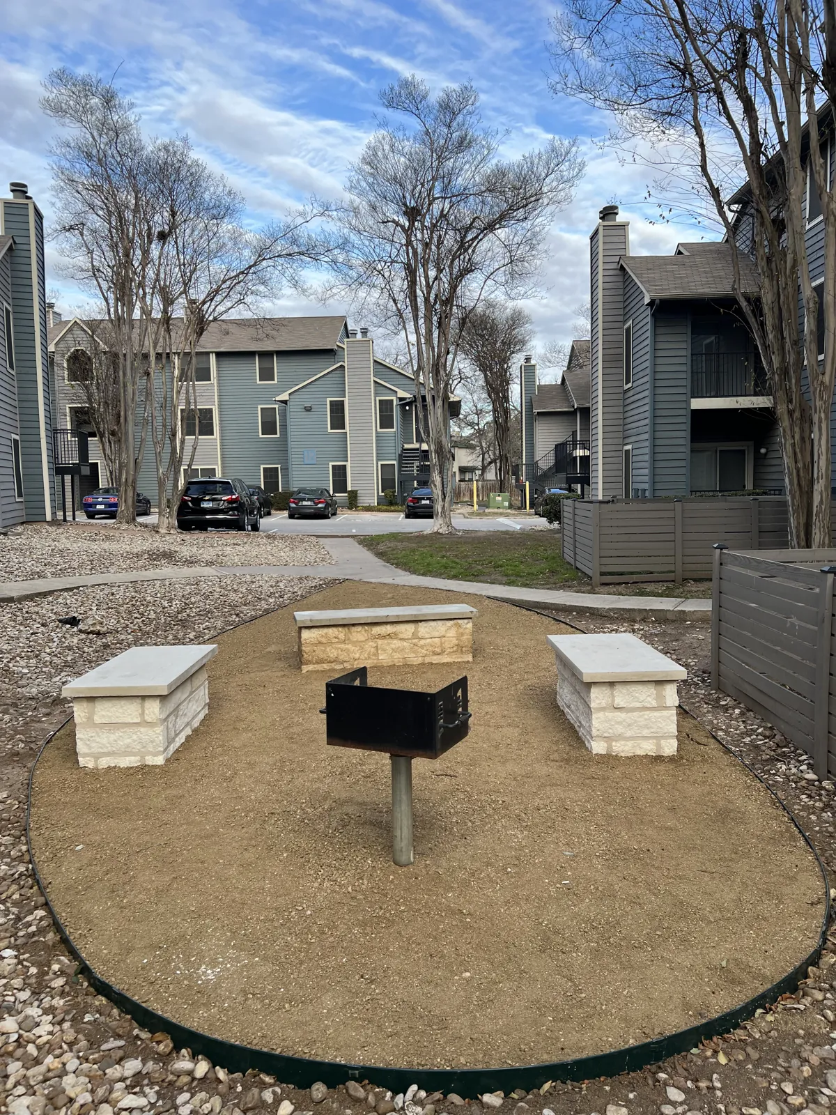 Gravel gathering area, stone benches and rock beds at SoNA Apartments.