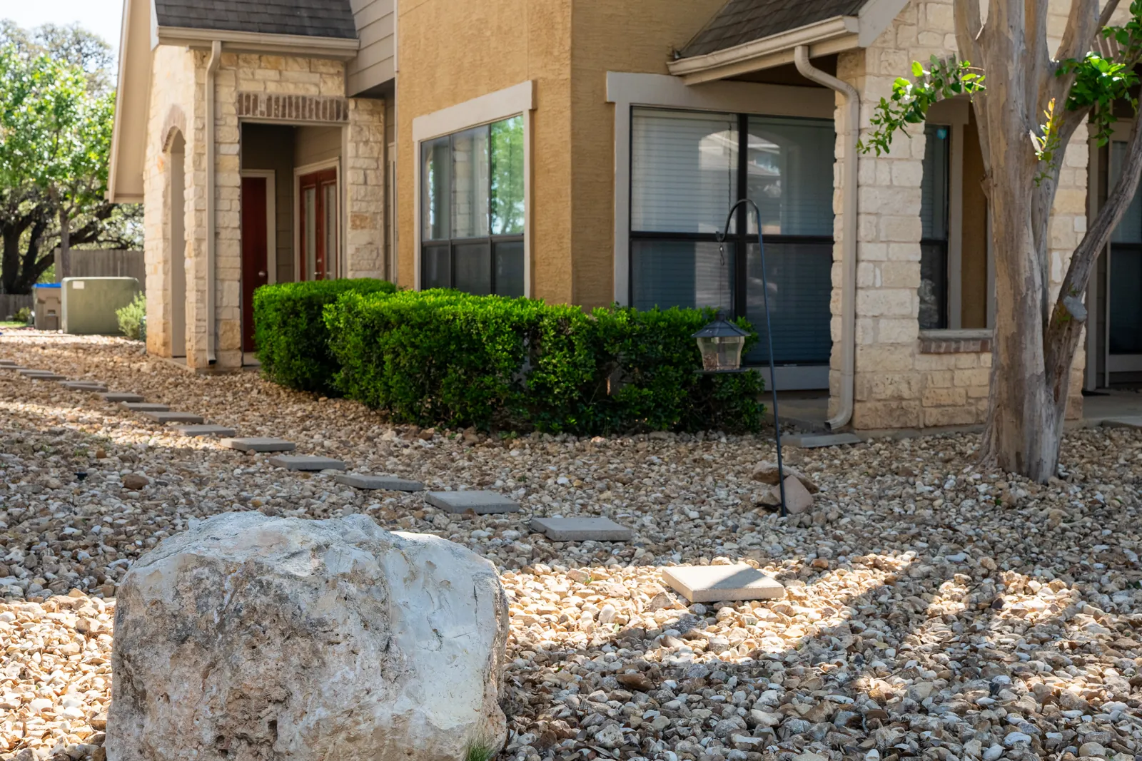 Stepping stones connect townhome entrances through river rock beds.